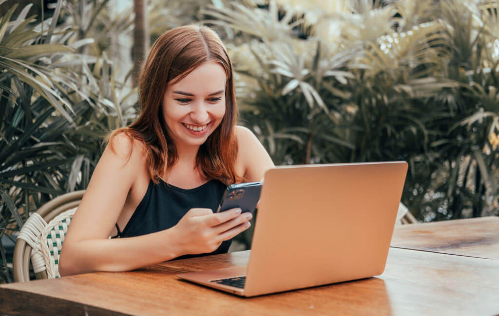 Woman on her laptop and phone | Automate Facebook ads