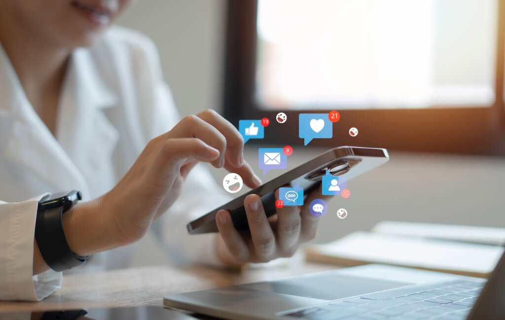 Social media icons floating above phone | Automate LinkedIn ads