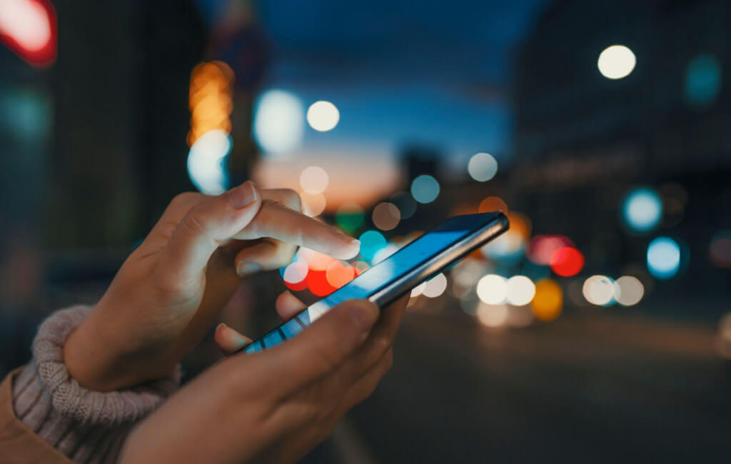 Hand holding a smartphone | Automate Facebook ads