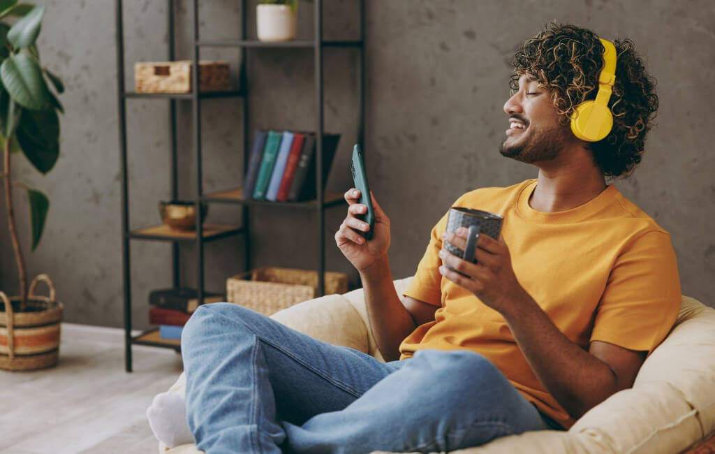 Man sitting on a couch wearing headphones | Spotify’s North Star Metric