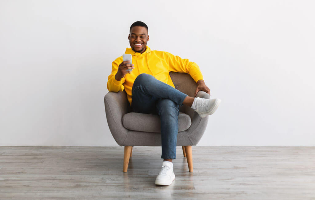 Man using his phone on chair | Why is mobile advertising important? 