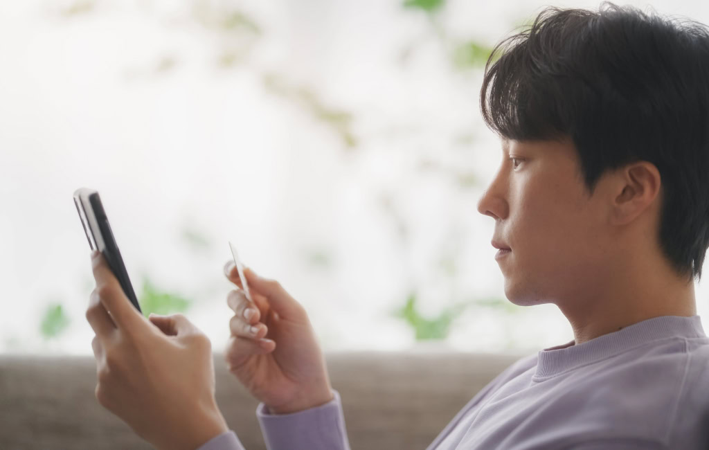 Man purchasing an item on his phone | Ecommerce marketing strategies