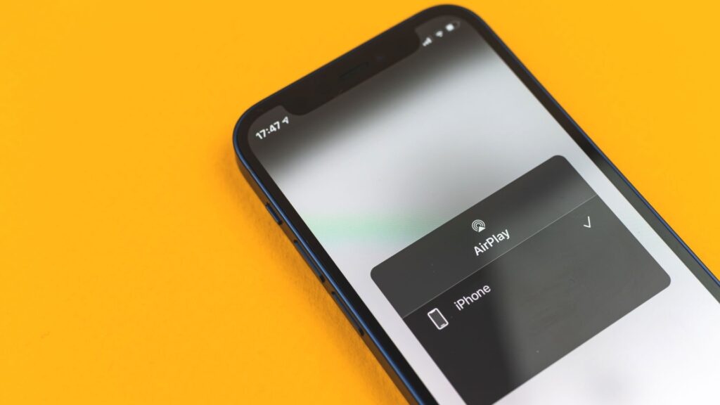 Airplay menu selection shows on iPhone sitting on yellow background | Embedding Network Effects