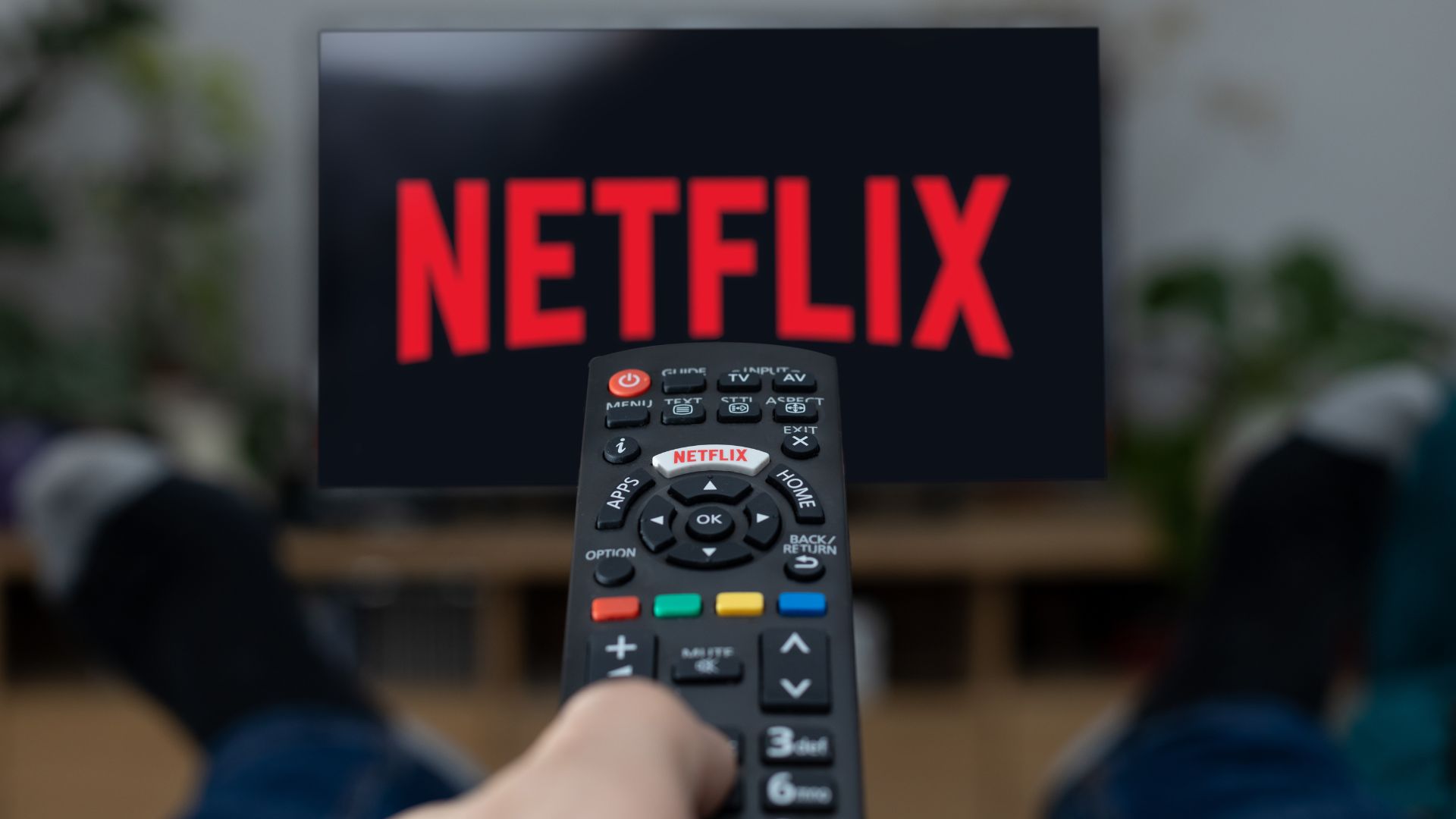 Close up of person pointing TV remote at screen displaying Netflix logo | Brand Network Effects Case Study