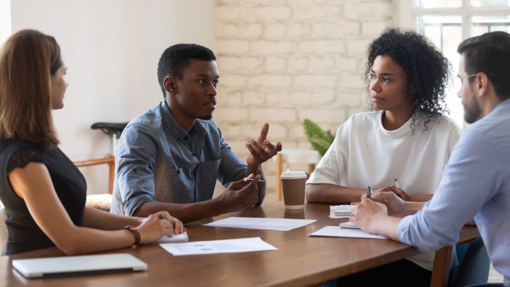 SaaS team members discussing product challenges during meeting | Measuring Network Effects