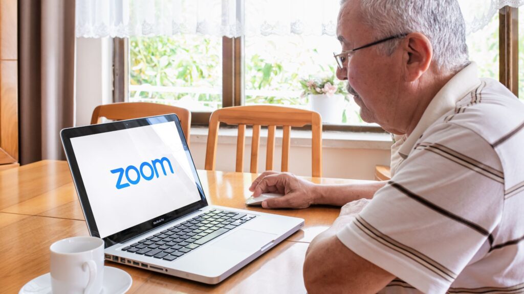 Senior man sits at dining table and launches zoom software on laptop computer | Finding the Right SaaS Users