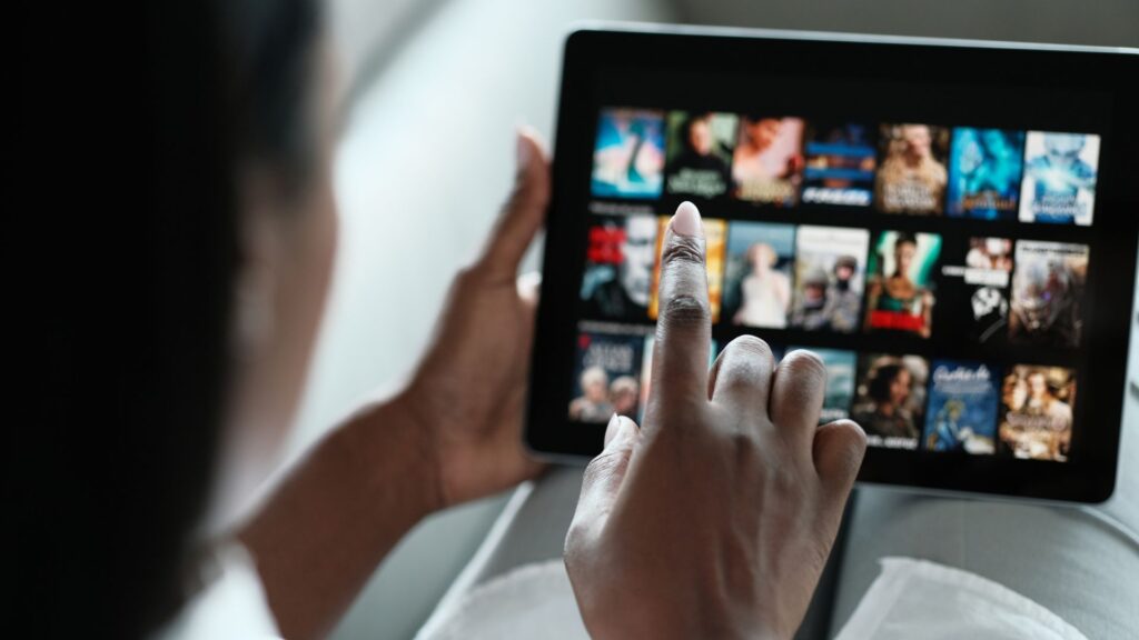 Woman scrolls through movie titles on netflix using tablet | Maximize Brand Network Effects