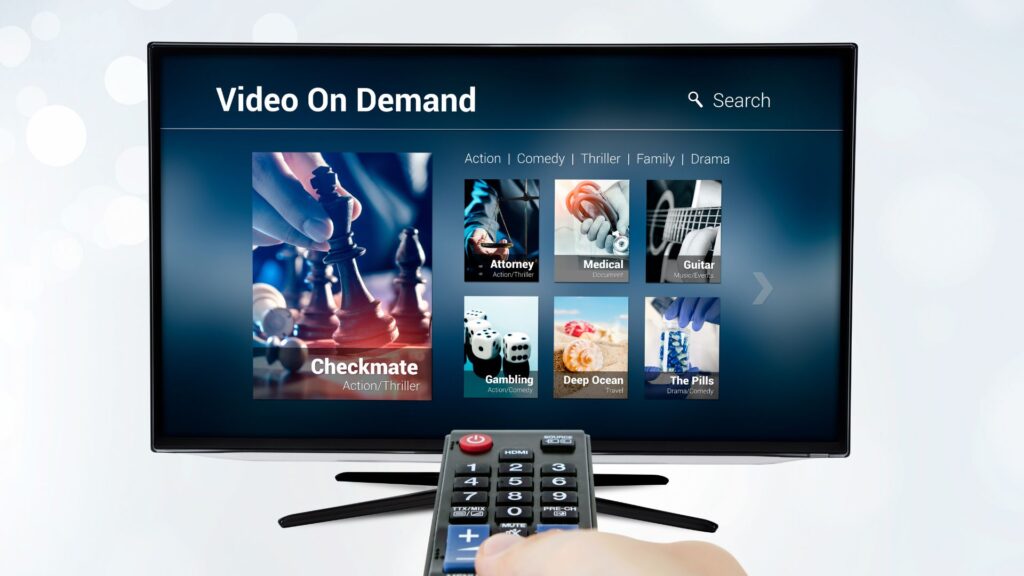 Person holding TV remote up to a screen displaying videos on demand | Monetization and Pricing Strategies