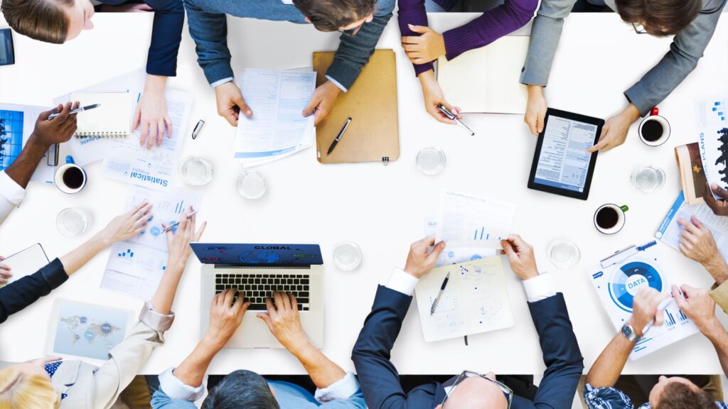 Aerial view of SaaS team looking at paper reports on user engagement | User Resurrection for SaaS Companies