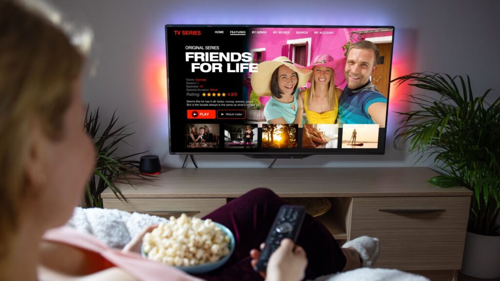 Woman sits on couch while scrolling through titles on Netflix | User Activation for Streaming Companies