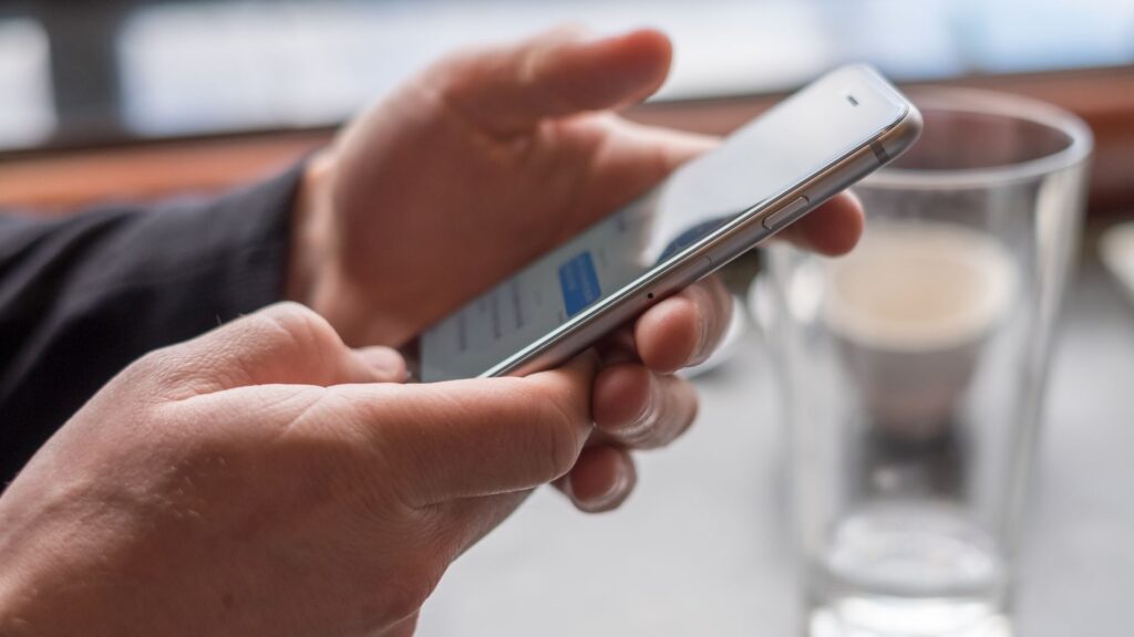 Close up of person texting on silver iPhone | User Resurrection for SaaS Companies