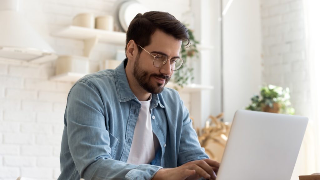 Man Working on Laptop While Smirking | Types of Growth Loops | Teknicks